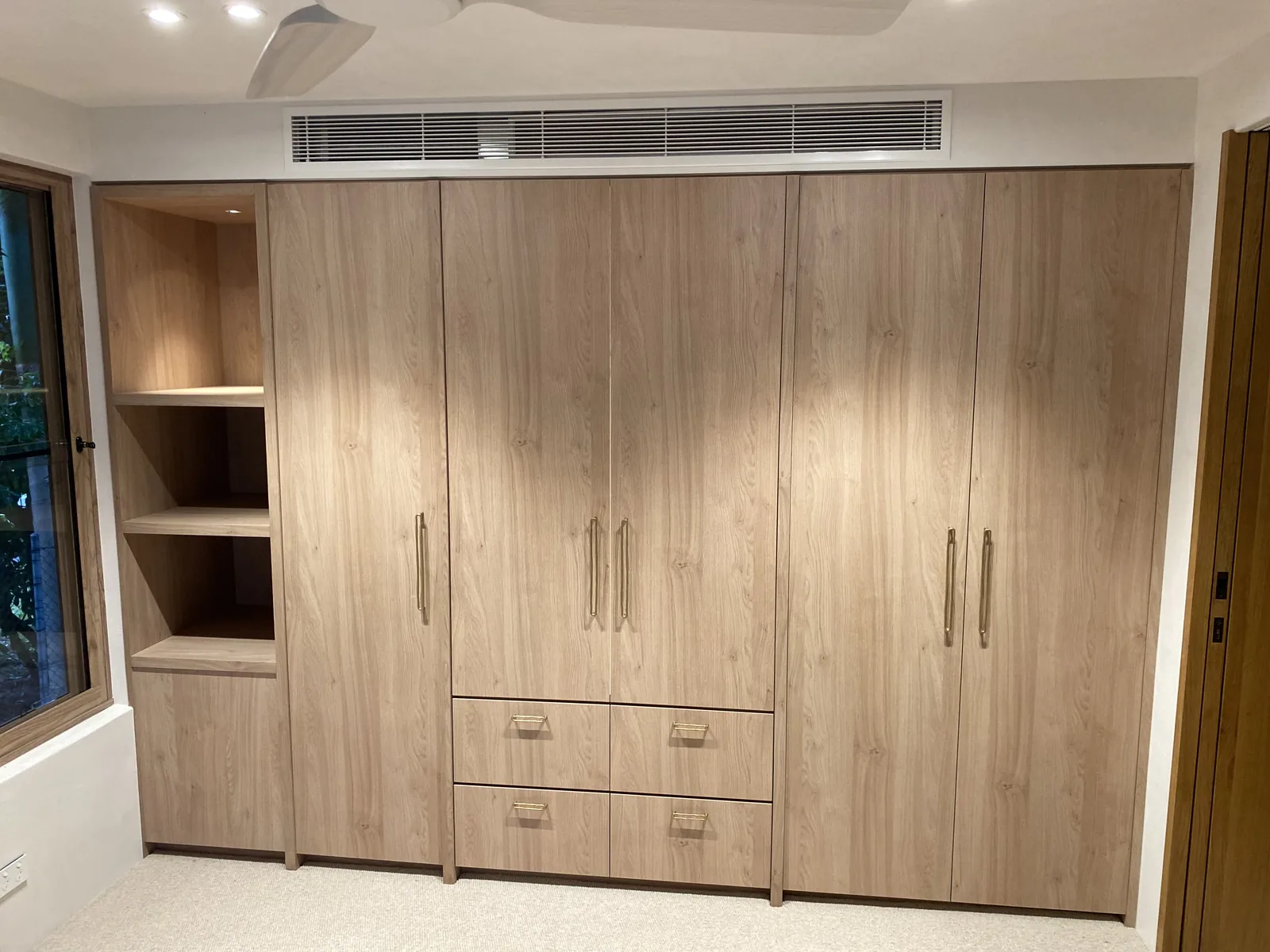 Oak built-in wardrobe with open shelving and drawers
