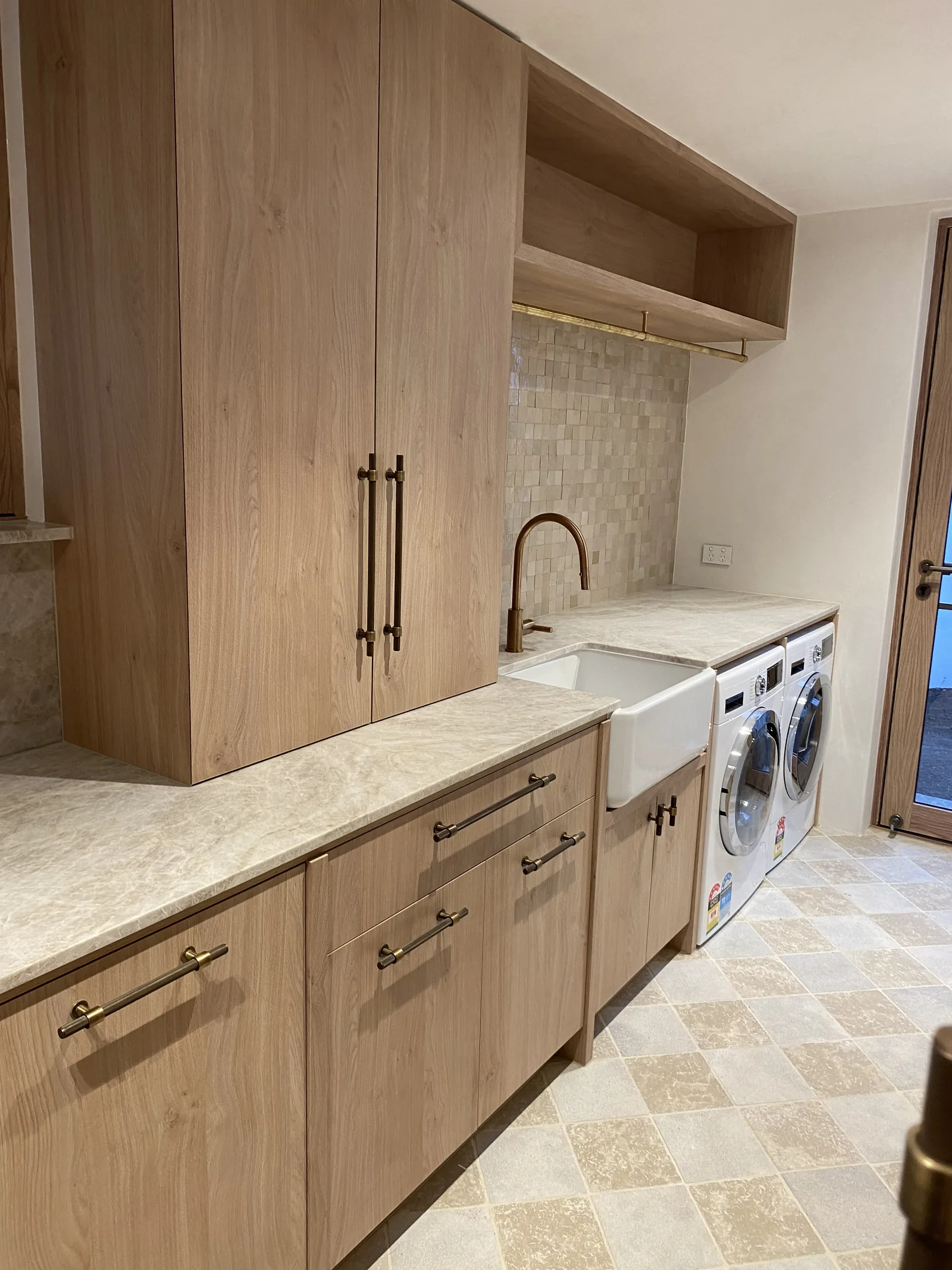 Oak laundry with stone benchtop and farmhouse sink