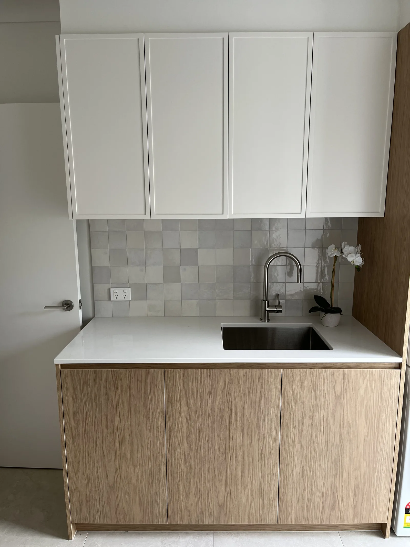 White shaker and oak laundry with tiled splashback
