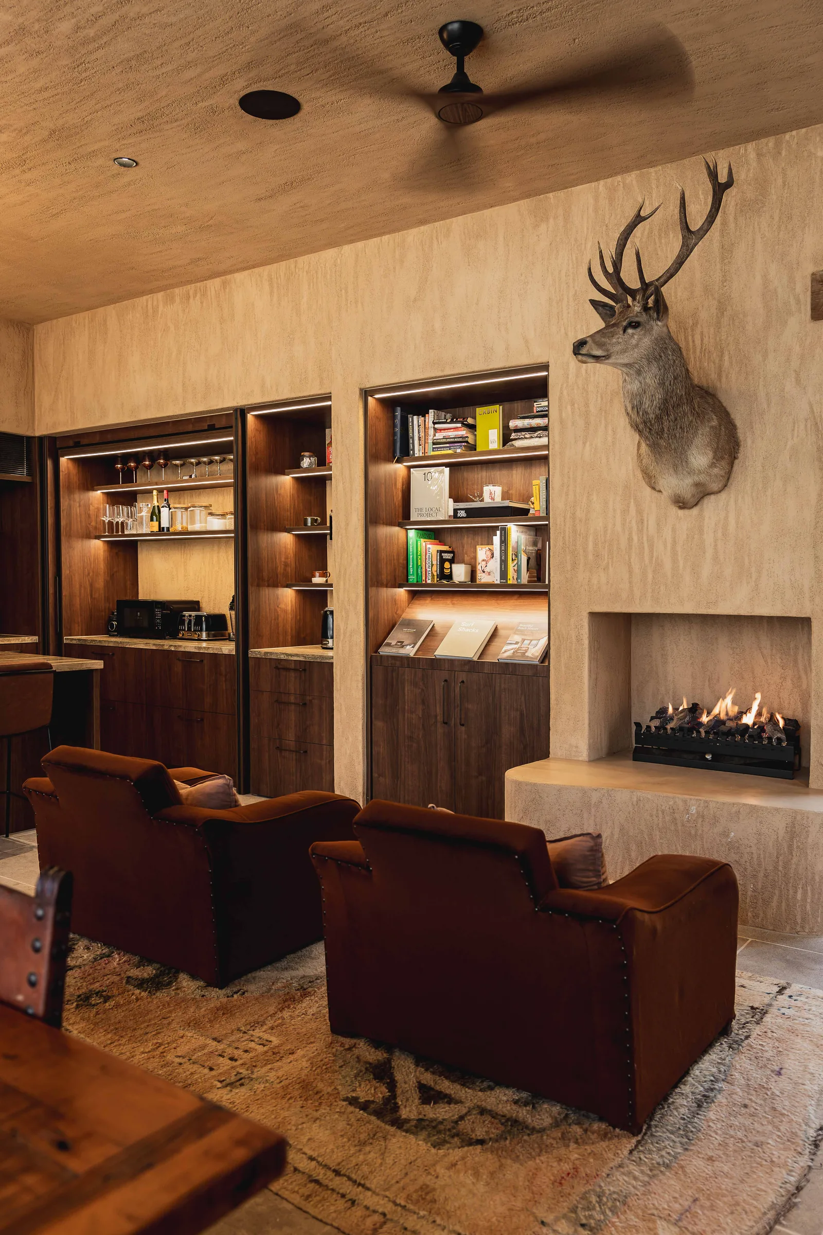 Living room with timber shelving joinery beside a fireplace