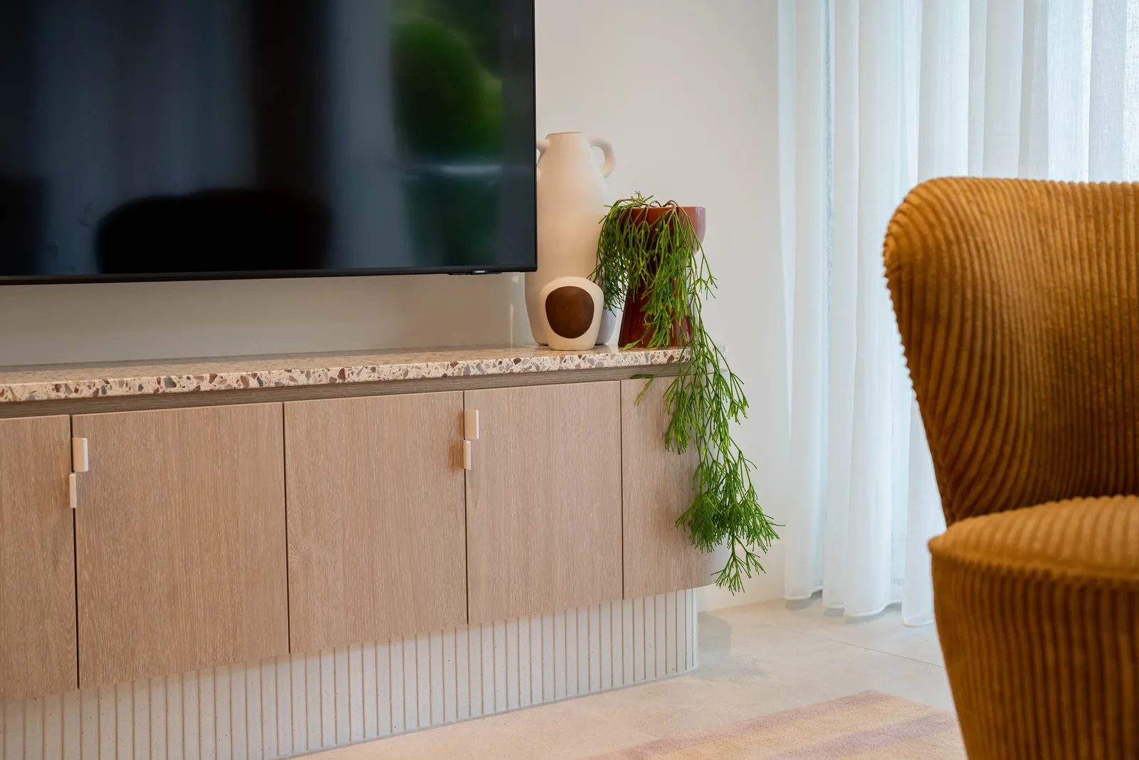 Fluted oak TV unit with terrazzo top