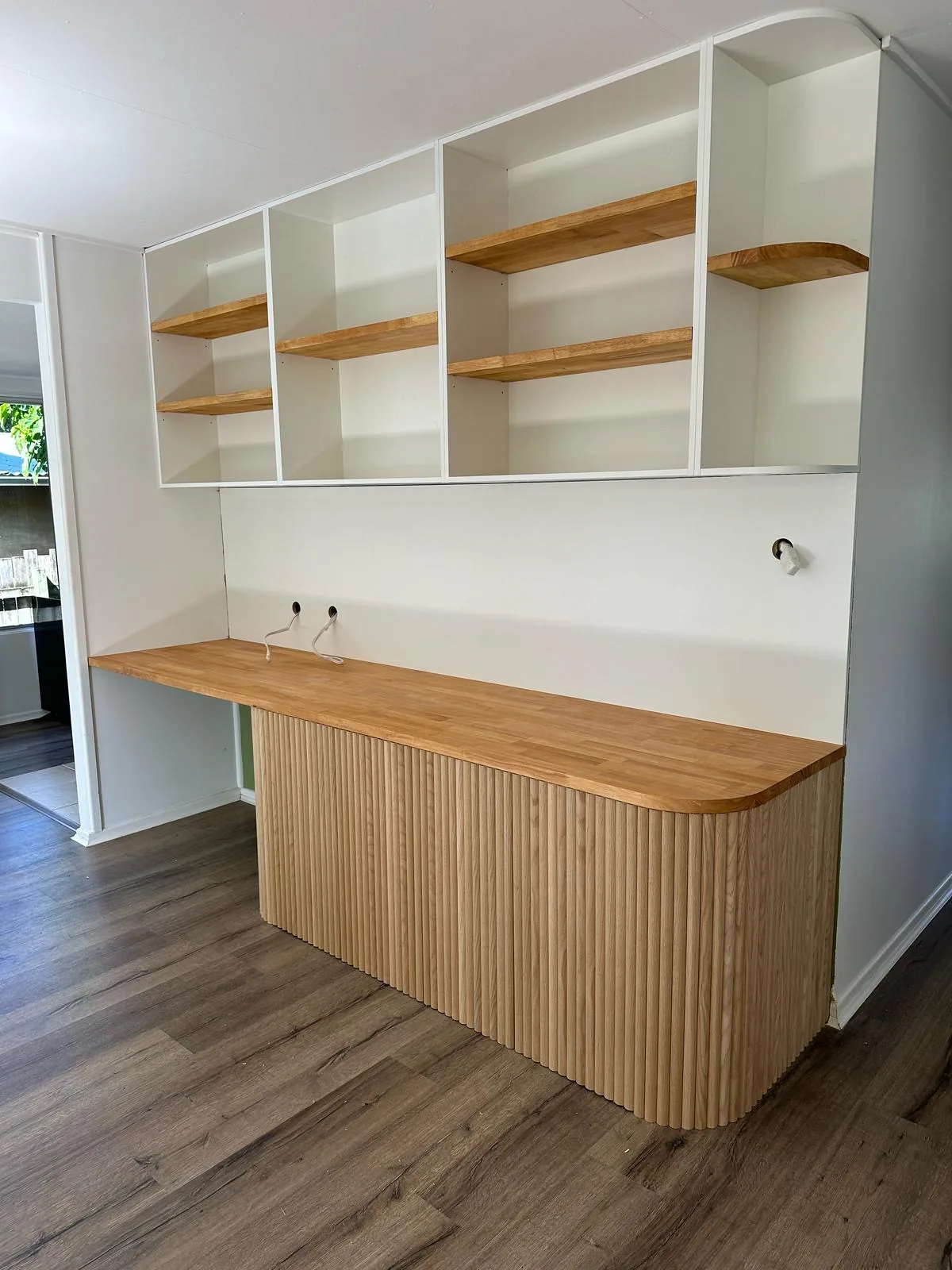 Curved oak desk with open shelving above