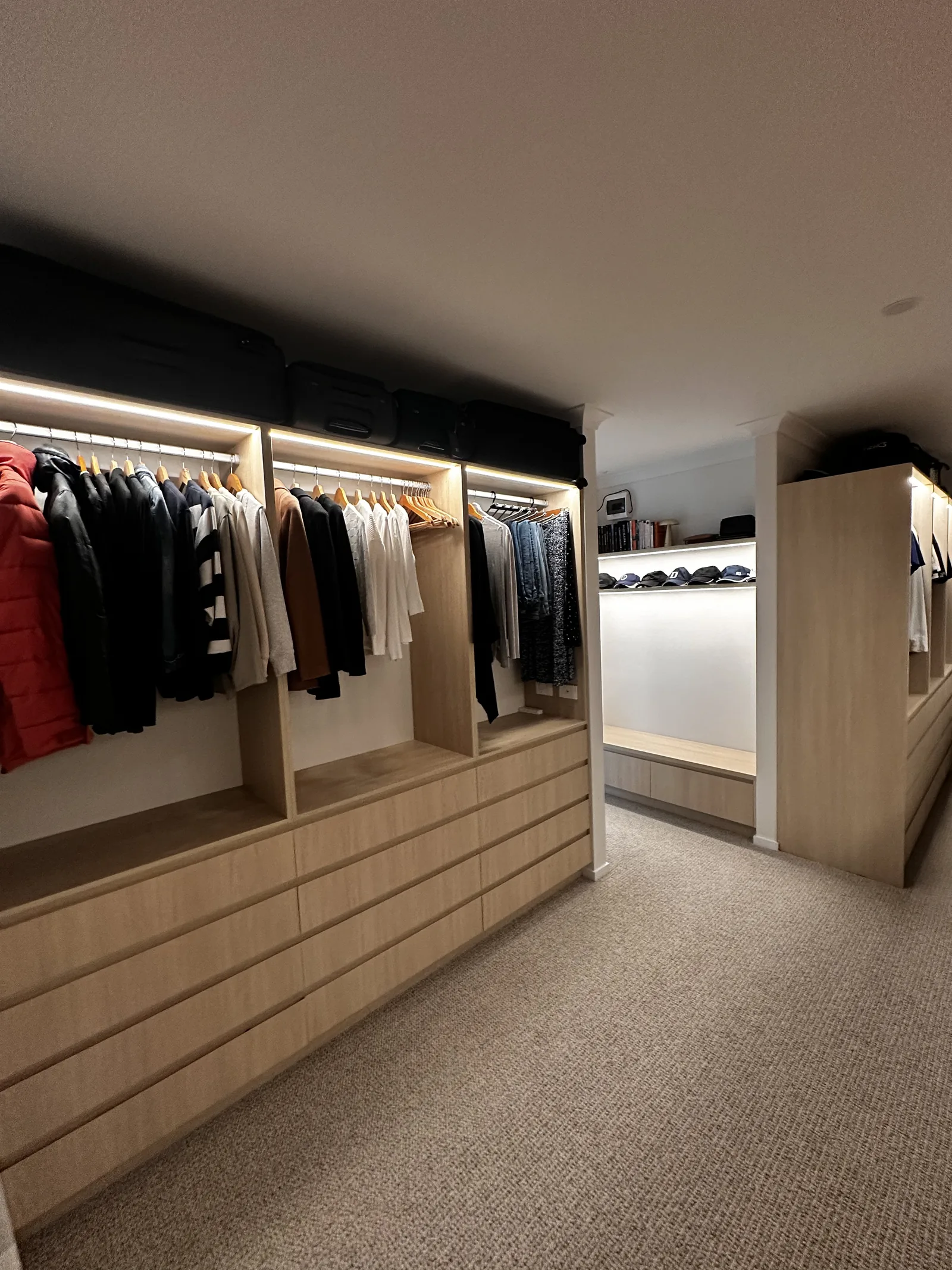 Walk-in dressing room with lit rails, drawers and island